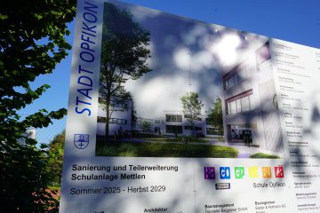 News 1.10.25 - Grosse Bautafeln geben Auskunft über die geplanten Sanierungs- und Erweiterungsarbeiten in der Schulanlage Mettlen.